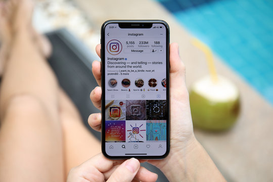 Woman hand holding iPhone X with social networking service Instagram