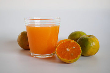 Orange juice in glass and orange fruit on white background, Zoom macro.