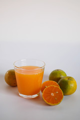 Orange juice in glass and orange fruit on white background, Zoom macro.