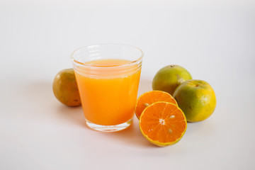 Orange juice in glass and orange fruit on white background, Zoom macro.