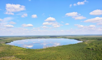 Forest lake with blue sky reflection