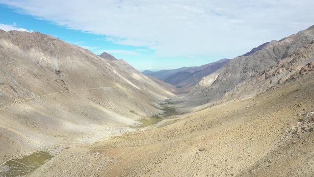 An aerial view inside Andes mountains at Limari Valley, south Atacama. An amazing wild scenery. Arid idyllic valleys with green farm fields feed in by the river at the bottom of the valley
