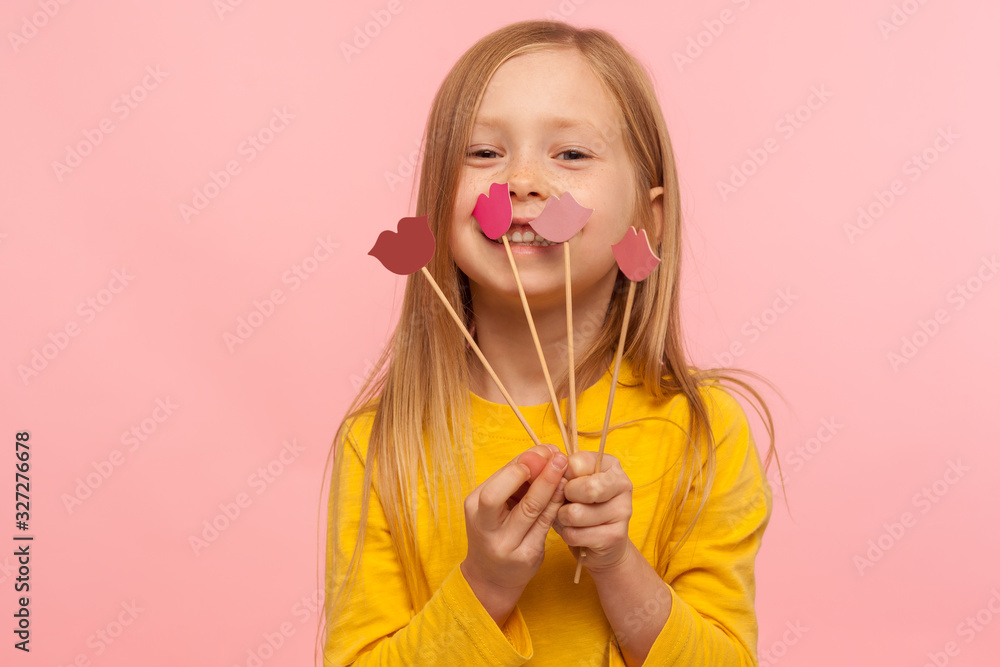 Wall mural portrait of lovely pretty little girl smiling, holding few red pink paper lips on sticks, choice of 