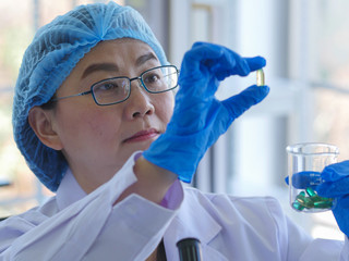 Senior scientist checking quality of medicine.