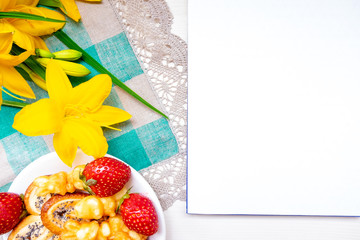 Valentine's day strawberry cookies hearts with coffee, with yellow flowers on a napkin for a note