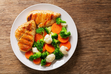 plate of grilled chicken with vegetables, top view