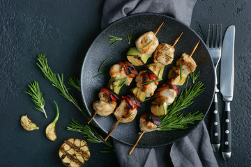 chicken kebab with vegetables on a dark background