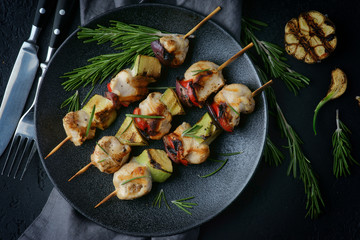 chicken kebab with vegetables on a dark background