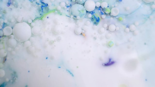 Slow motion of bright colored bubbles. Beautiful oil colors of the universe. Multi-colored close-up. Acrylic paint. Fantastic hypnotic surface. Abstract colorful blister metamorphosis texture