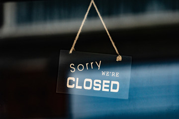 sorry we are closed sign hanging outside a restaurant, store, office or other