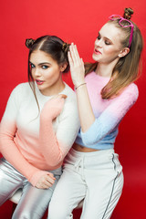 two best friends teenage girls together having fun, posing emotional on red background, lifestyle people concept