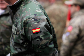 Details with the uniform and the flag on it of a Spanish soldier taking part at the Romanian...