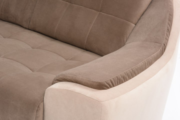 Closeup of cream and brown colored sofa resting arm