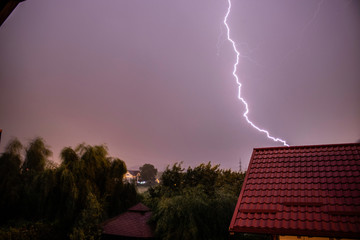 Naklejka na ściany i meble Lightning storm over a residential area