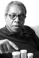 Male senior taking his medication at home.