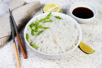 A bowl of cooked rice with chopsticks. Classic Japanese side dish.Close up