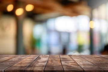 Lege houten tafelblad en vervagen glazen raam interieur restaurant banner mock up abstracte achtergrond - kan worden gebruikt voor weergave of montage van uw producten.