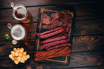 beer snacks. bar table. pub, oktoberfest. variety of delicious appetizers. sausages, jerky, meat delicatessen. friday party atmosphere craft brewery concept