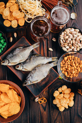 Pile of varied beer snacks on a wooden table. Fast food assortment. Bar, pub, restaurant concept