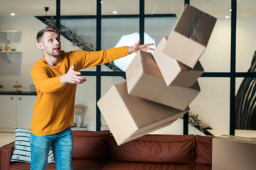 Young adult man move in new accommodation dropping boxes on floor