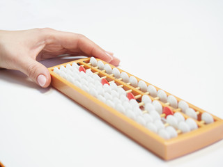 Classes in mental arithmetic, hands and abacus soroban on white background. closeup. copy space