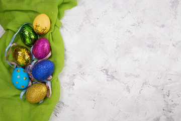 Easter background. Colored eggs with sequins on the fabric