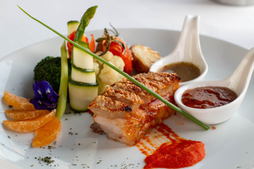  crispy pork with sauce on white plate