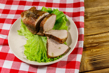Tasty baked pork with spices on a wooden table