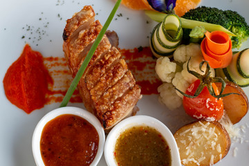  crispy pork with sauce on white plate