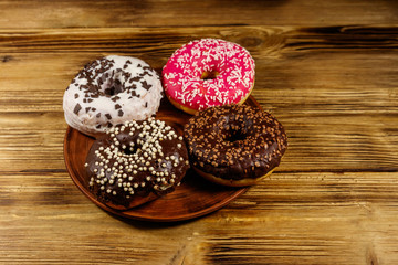 Tasty donuts on plate on a wooden table