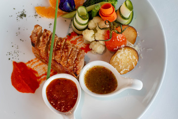  crispy pork with sauce on white plate