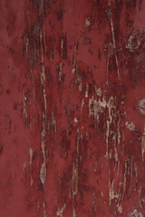 old wood door painted with red paint from age cracks
