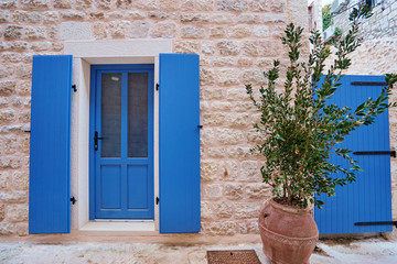 Fototapeta premium White old building with blue wooden vintage door.