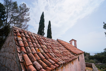 Ancient small catholic chapel made from stones with tiled roof.