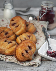 food photography of confectionery cake with berry jam filled with a glass jar and cooking utensils and ingredients on a gray textured concrete background