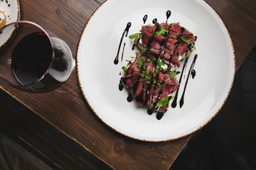 bruschetta set with smoked meat, an arugula over a rough wood background. Top view