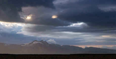 Obraz premium Mountain peak with snow and clouds during dramatic and colorful sunset on the laugavegur Hiking trail close to Thorsmork
