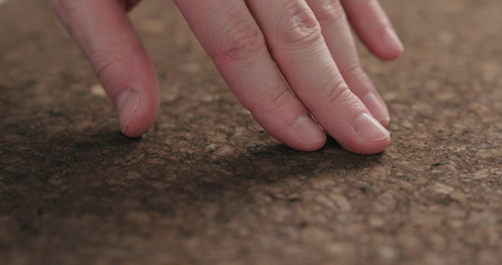 man hands touch dark cork surface