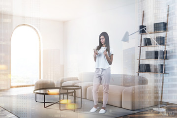 Fototapeta na wymiar Woman with phone in white living room with sofa