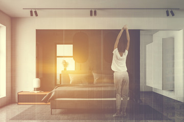 Woman in white bedroom and bathroom