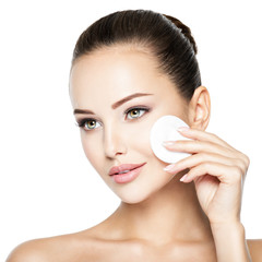 Beautiful woman cleans the face with  cotton swab.