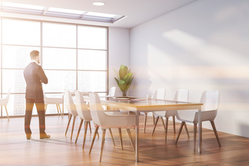 Businessman in panoramic white cafe interior