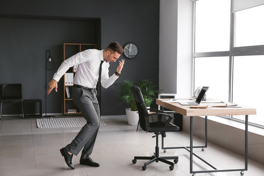 Young businessman dancing in office
