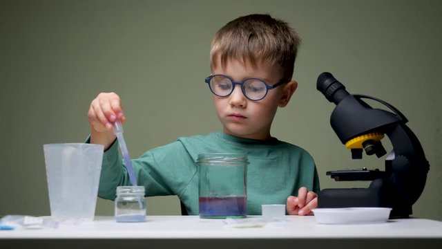 Young scientist making experiments in home laboratory. Intersting science. Boy studying natural or physical sciences. Expert knowledge background. COVID-19 vaccine development.