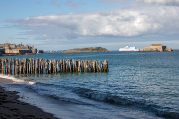 Fototapeta na wymiar Passenger ferry leaving the port of Saint Malo in the morning in the direction of United Kingdom