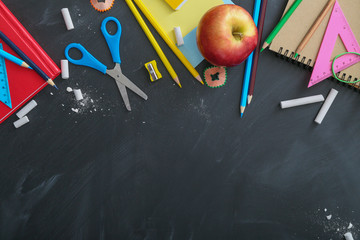 Set of school stationery on blackboard