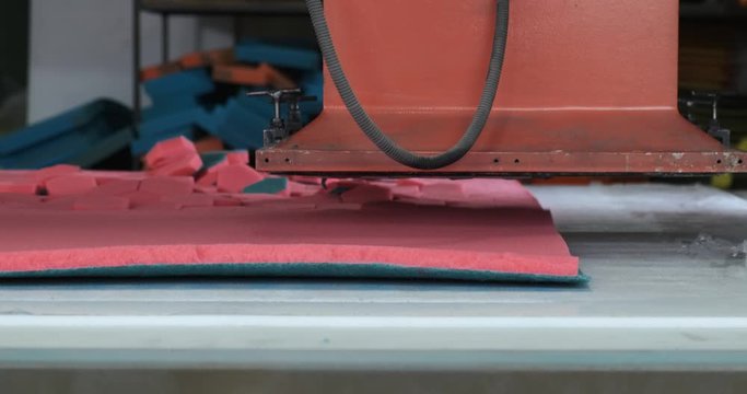 Heavy machine tool cuts out hexagonal workpieces from sheets of synthetic material, manufacturing paralon sponges for households, factory floor, automatic process, press, pressing, hexagonal shape