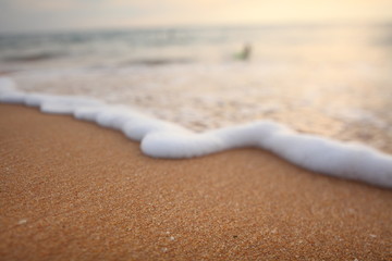 foam on sandy tropical ocean beach