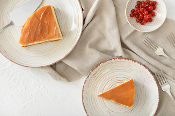 Slices of sweet caramel cheesecake on white background