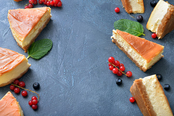 Slices of sweet caramel cheesecake with berries on dark background